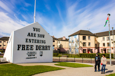 The 'You are Now Entering Free Derry' Corner in Londonderry, Northern Ireland, with two passersby