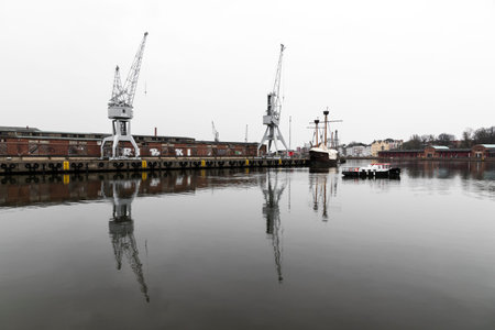 Lubeck, Germany. Boat and cranes at the harbor in the river Trave in Lubeck