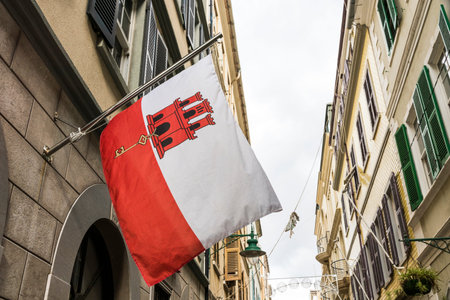 Gibraltar, UK. Flag of Gibraltar waving from one of the houses in Main Street. A British overseas territory disputed by Spainの写真素材