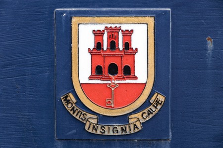 Gibraltar, U.K. Coat of arms of the British Overseas Territory of Gibraltar on a blue backgroundのeditorial素材