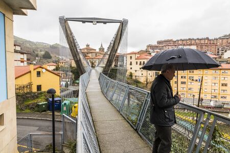 Cangas del Narcea, Spain. The Collegiate Church of Saint Mary Magdalene, seen from the Puente Colgante (Hanging Bridge)のeditorial素材