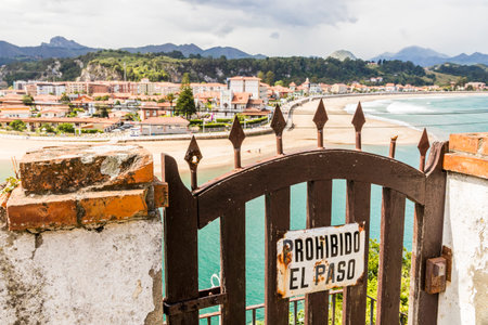Ribadesella, Spain. A No trespassing sign with views of the coast town of Ribadesella in Asturias on a warm summer dayの写真素材