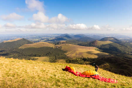 Man preparing for Paragliding in Puy de Dome, with the Chaine des Puys volcanoes in the backgroundのeditorial素材