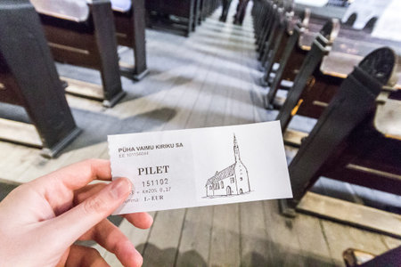 Tallinn, Estonia. Hand holding an entrance ticket to the Church of the Holy Spirit (Puha Vaimu...