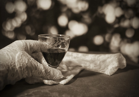 White lace gloves and a glass of cherry brandyの写真素材