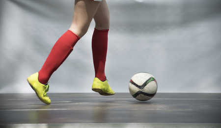 A close-up of legs of a girl playing footballの写真素材