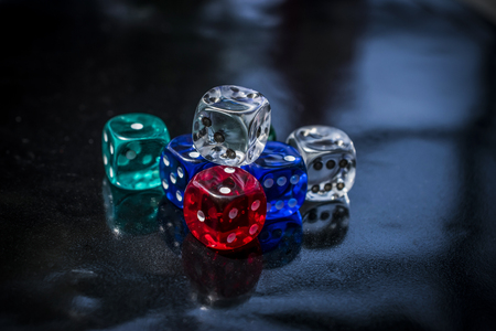 A set of colorful D6 dice on a black tableの写真素材