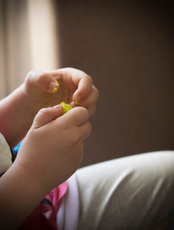 A close-up of a child's hands while playing with plasticine
