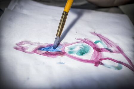 A close-up of a brush drawing with water colors on natural lightの写真素材