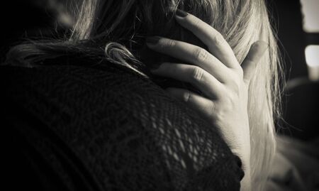 A worried woman from the back in black and whiteの写真素材