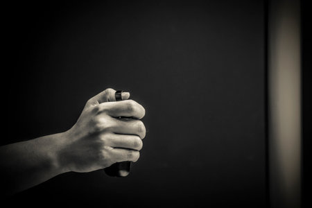 A male hand with a remote controller in black and whiteの写真素材