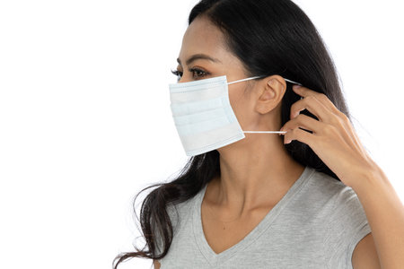 Portrait of an Asian woman wearing a medical flu mask to prevent coronavirus. isolated on white...