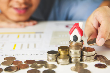 Men's hand is planning savings money of coins to buy a home concept