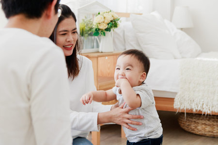 Asian parents play with baby in the bedroom. Happy Family Concept