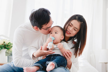 Asian young family Consisting of parents and babies They embrace each other and smile happily. Happy...