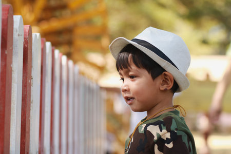 An Asian boy looks at the animals in a cage. He smiled happilyの写真素材