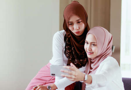 Two muslim women Take a self-portrait with a smartphoneの写真素材