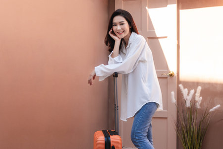 Asian woman posing in trendy look. Portrait of a smiling brunette women natural makeup wear fashion clothes going to travel. Beautiful female model wearing a big white shirt. people beauty concept.の写真素材