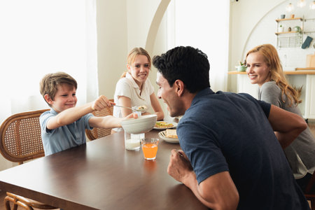 Happy Caucasian family talking to each other during breakfast together at home. father mother talk...