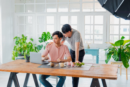 Transgender couple coordinates product placement and takes pictures with smartphone. Asian men...