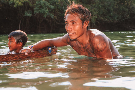 Young indian man from the Asurini Amazon tribe bathing in the Xingu  River. Brazil, 2009.