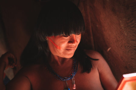 Beautiful indian woman looking at herself in the mirror. ArawetÃ© tribe, Amazon, Brazil.  2010.