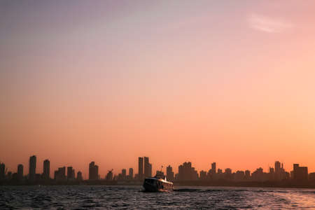 Photo pour Riverside sunrise view of the skyline of BelÃ©m do ParÃ¡, metropolis of the Brazilian Amazon, with small ferry boat on the foreground. July, 2008. - image libre de droit