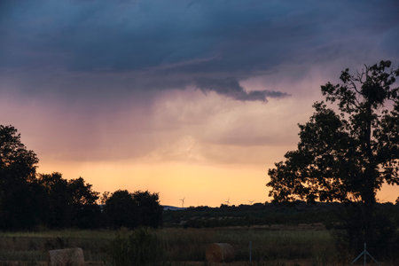 Black storm clouds over a flat landscape of central Spain on a summer afternoon during sunset....