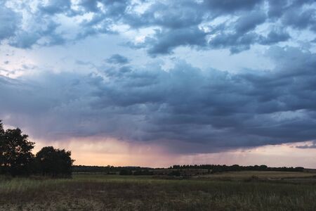 View of a water curtain in the distance on a plain in Spain, with storm clouds in the sky. Relating to weather, travel, meteorology and natureの写真素材