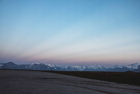 Mountainous landscape of snowy peaks seen from a hill on the other side of the valley in Asturias. Relating to nature, excursions and hiking in northern Spainの写真素材