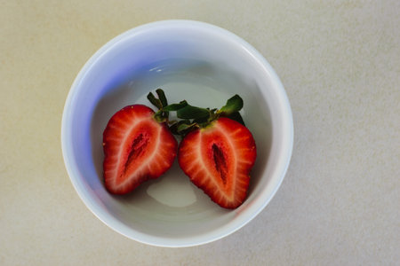 Strawberry cut in half in a white bowlの写真素材