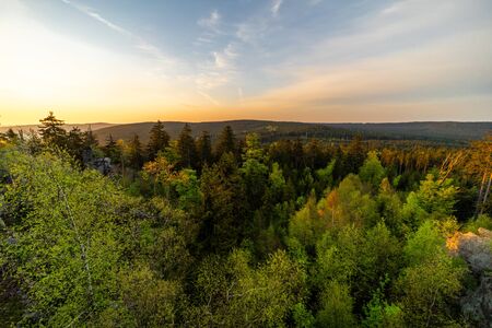 Sunbeams falling on rocks and forest at sunriseの写真素材
