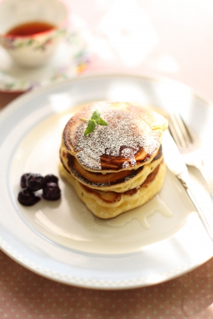 Pancake and honey on dish with english teaの写真素材