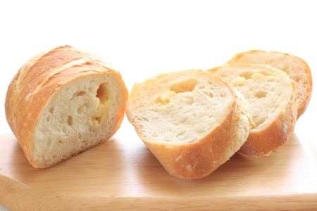 sliced cheese baugette on chopping boardの写真素材