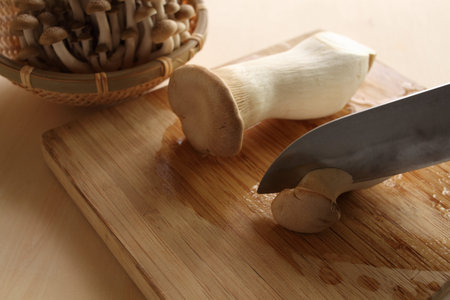 cutting of eringi on wooden boardの写真素材
