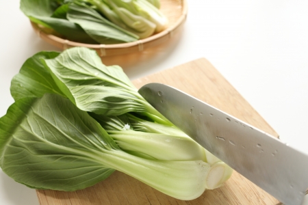 Chinese green leaf vegetable on chopping boardの写真素材