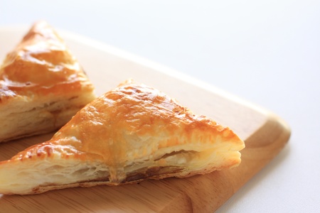 meat pie in triangle shape on wooden bread boardの写真素材