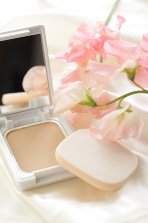 Foundation and sponge with flower on backgroundの写真素材