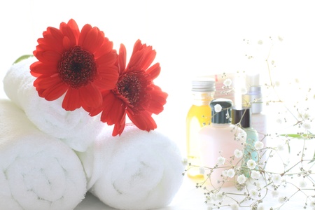 red gerbara on towel wtih skin care lotion on background for beauty salon imageの写真素材