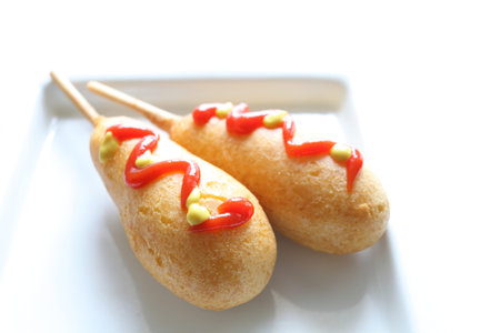 Corn dog with ketchup and mustard sauce on dish for fastfood image