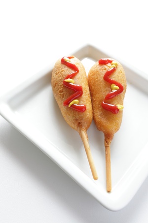 Corn dog with ketchup and mustard sauce on dish for fastfood imageの写真素材