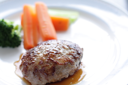 Homemade hamburger steak served with carrot and broccoliの写真素材