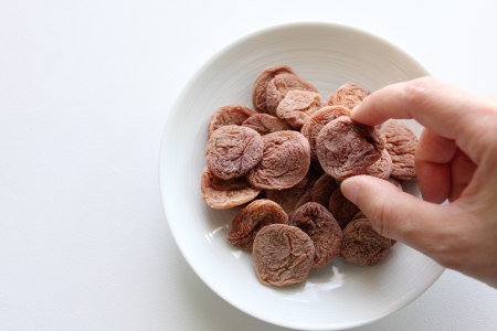 Chinese food, dried plum and handの写真素材