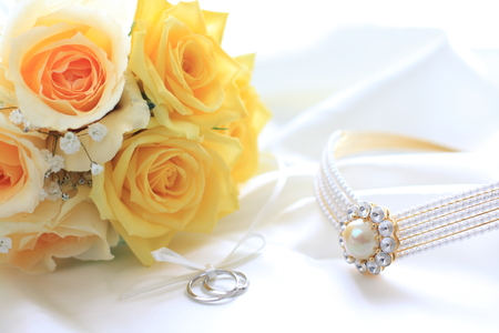 yellow roses bouquet and wedding ringsの写真素材