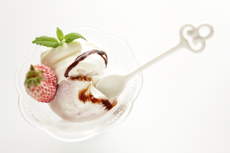 Vanilla ice-cream with frozen strawberry and chocolate sauce on topの写真素材