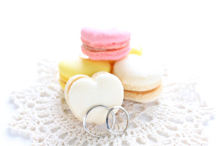 Heart shaped macaroon and wedding ringsの写真素材