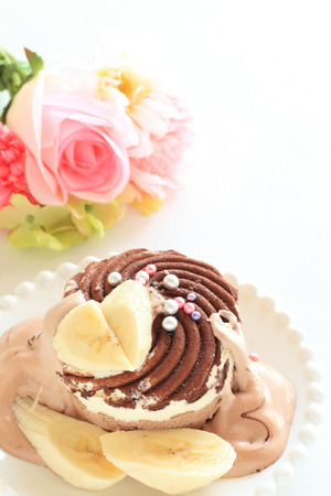 Chocolate ice cream served with banana and creamの写真素材