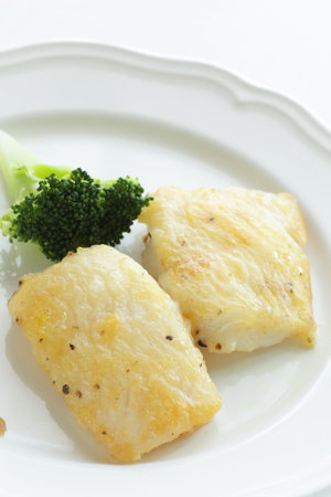 Cheese and flat fish fillet sauteed on dish served with broccoli