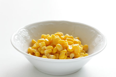 Sweet corn in white bowl on white background with copy space