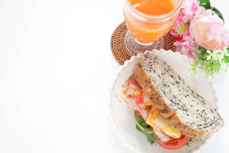 Bacon and fried egg sandwich for breakfast with carrot juiceの写真素材